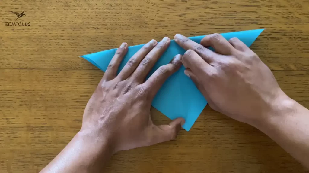 blue square origami sheet of paper folded in half diagonally