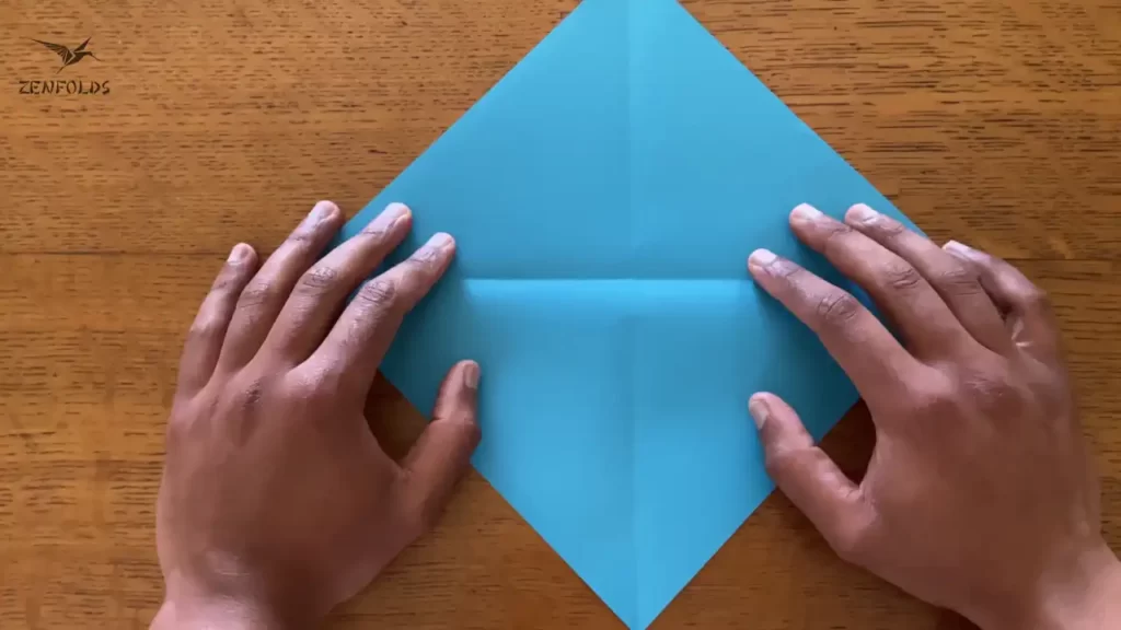 blue square origami sheet of paper with diagonal creases