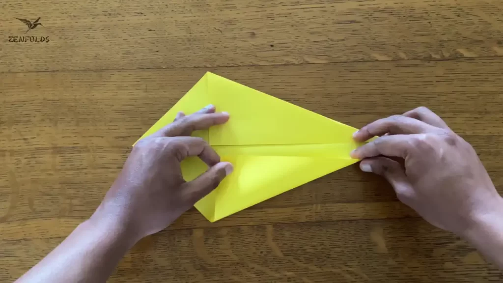 yellow square origami sheet of paper with the lower and upper left edges folded along a diagonal crease