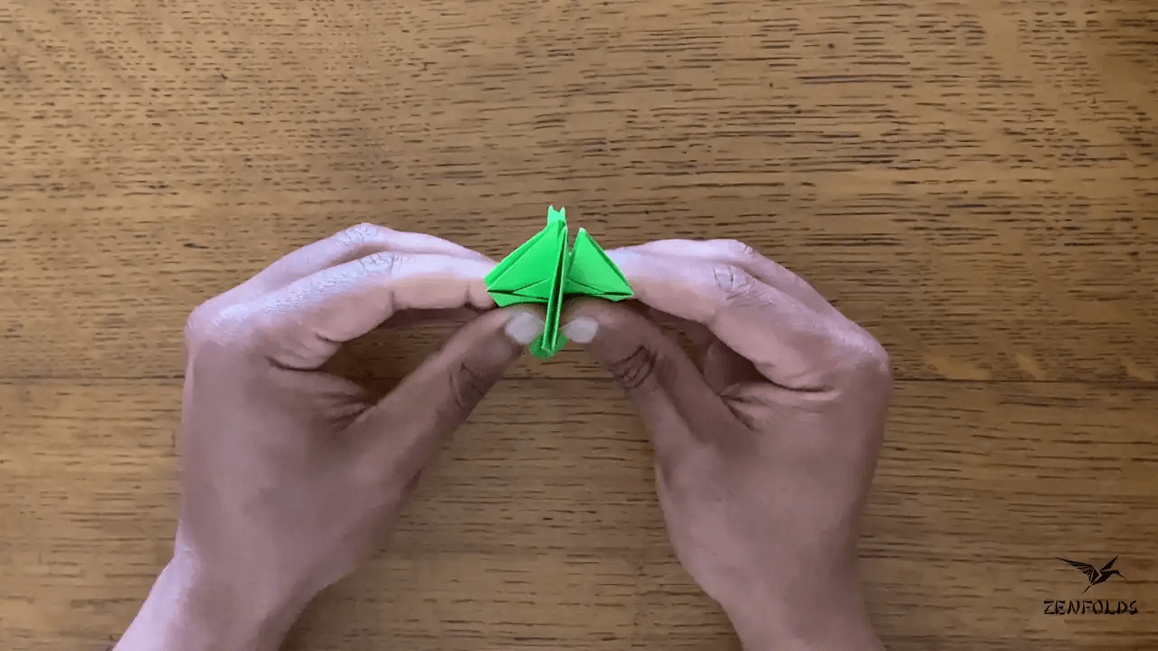 origami frog base being folded into an origami lily